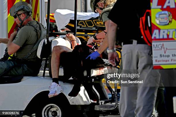 Medical personnel tend to a victim outside of Stoneman Douglas High School in Parkland, Fla. After reports of an active shooter on Wednesday, Feb....