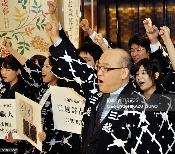 Japanese Mitsukoshi department store manager Hideaki Urabe and sales clerks wearing happi coats raise their fists as they launch the sales promotions...