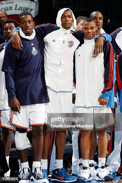 Jeff Greeen, Kevin Durant and Russell Westbrook of the Oklahoma City Thunder watch the end of the game from the bench against the Phoenix Suns during...