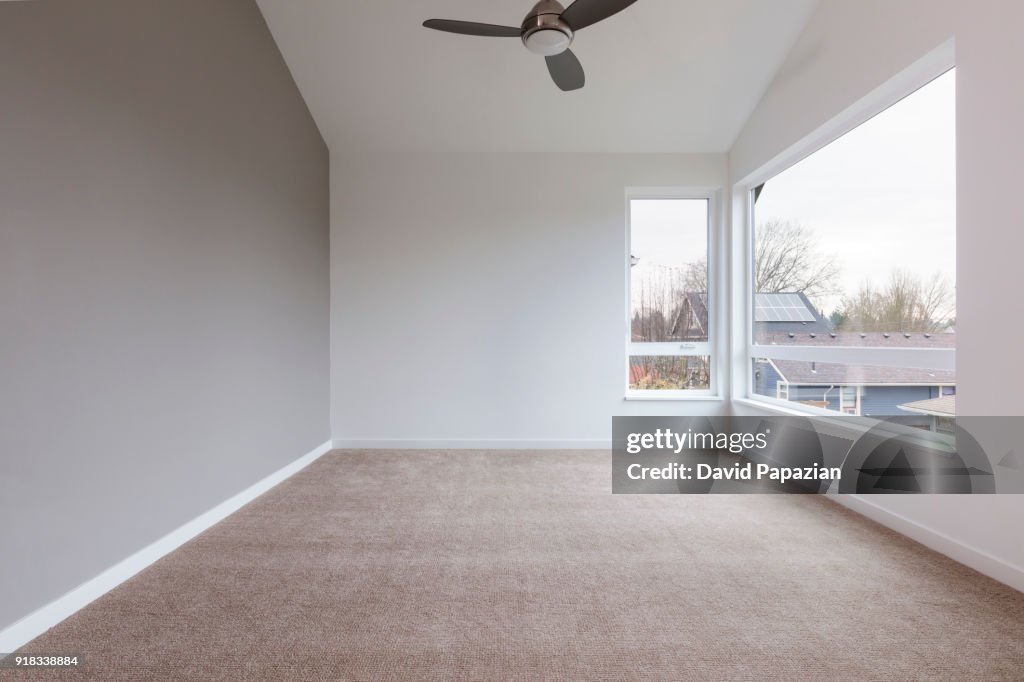 Bedroom view, interior with a big window and a ceiling fan