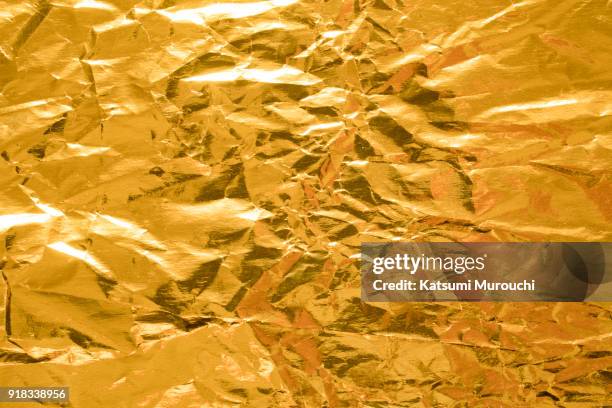 wrinkled gold foil texture background - foil stock pictures, royalty-free photos & images