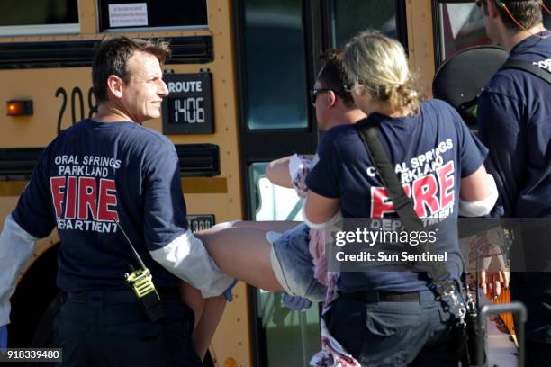 Medical personnel tend to a victim outside of Stoneman Douglas High School in Parkland, Fla., after a shooting on Wednesday, Feb. 14, 2018.