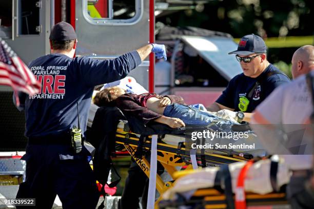 Medical personnel tend to a victim outside of Marjory Stoneman Douglas High School in Parkland, Fla., after a shooting on Wednesday, Feb. 14, 2018.