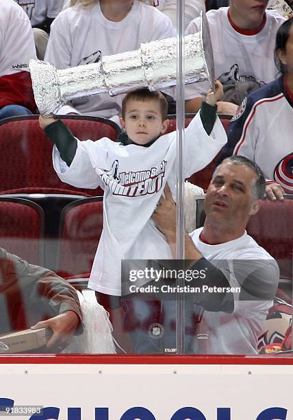 Young fan holds up a stanley cup in the NHL game between the Columbus Blue Jackets and the Phoenix Coyotes at Jobing.com Arena on October 10, 2009 in...