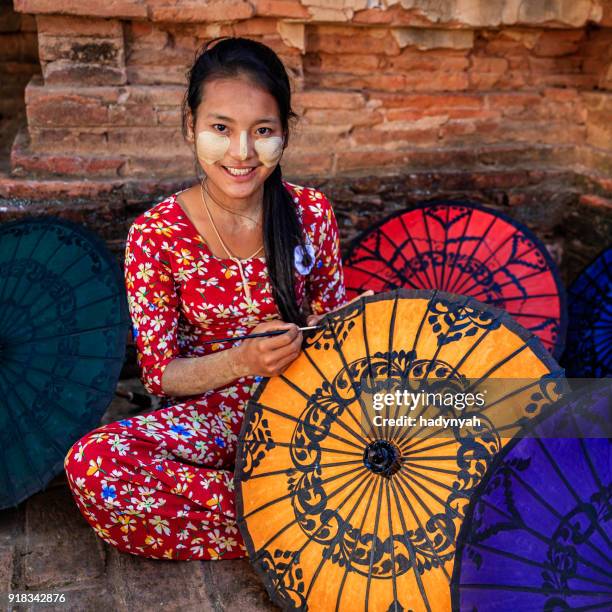 young burmese girl painting colorful umbrellas in bagan, myanmar - myanmar stock pictures, royalty-free photos & images
