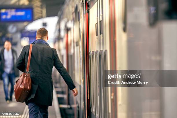 businessman, traveler on platform boarding a train at zurich central station - hauptbahnhof zürich stock-fotos und bilder