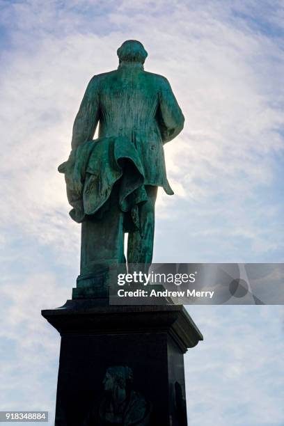 alfred escher statue in front of zurich central station zürich hauptbahnhof (zürich hb), view from behind statue towards bahnhofstrasse - escher stock-fotos und bilder