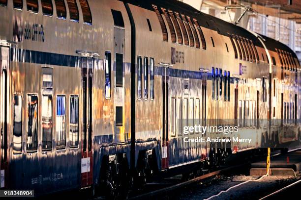 reflections on swiss train moving through zurich central station, switzerland - hauptbahnhof zürich stock-fotos und bilder