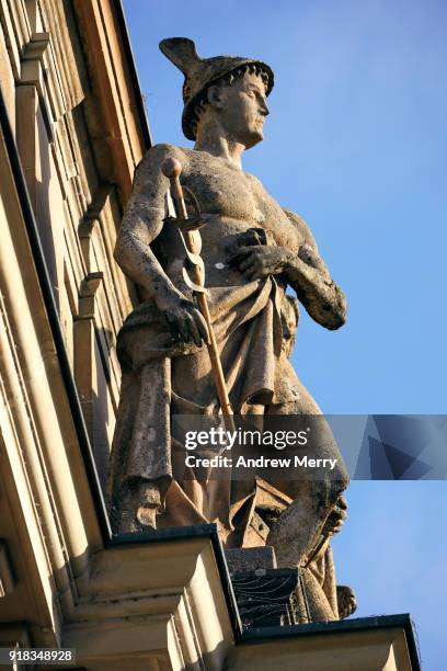 stone sculpture attached to the zurich main station sandstone building with blue sky - hauptbahnhof zürich stock-fotos und bilder