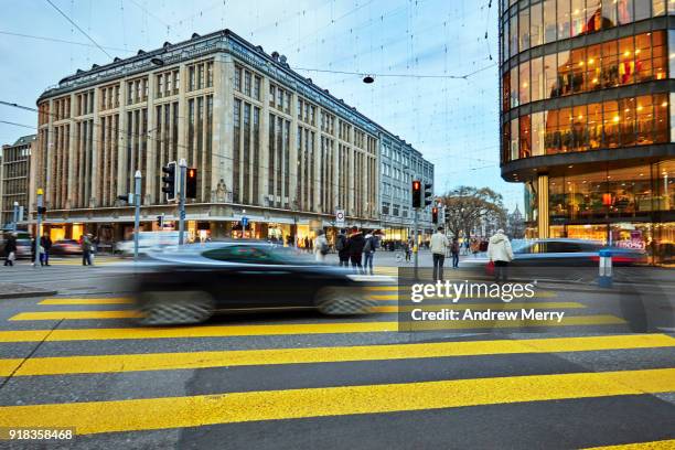 pedestrian crossing with electric car on the corner of bahnhofstrasse and uraniastrasse, zurich, switzerland - hora de ponta papel humano imagens e fotografias de stock