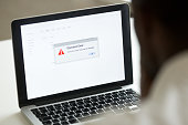 African man using laptop with application failure message on screen