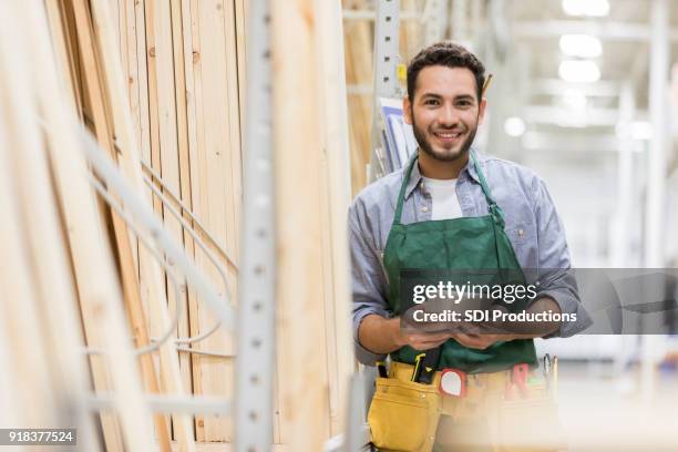 seguros de hombre trabajando en la yarda de la madera - madera material de construcción fotografías e imágenes de stock
