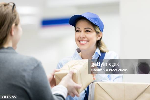 woman drops of packages at post office - post office stock pictures, royalty-free photos & images