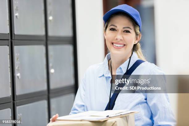 lachende vrouw mail vervoerder op het werk - postbode stockfoto's en -beelden