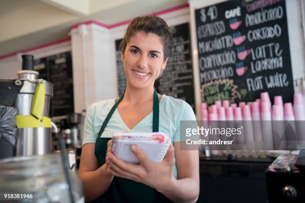 笑みを浮かべてカメラを見てメモ帳で、オルデンを取ってコーヒー ショップで美しい女性ウェイトレス - orden ストックフォトと画像