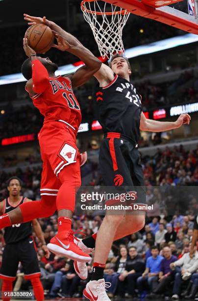 David Nwaba of the Chicago Bulls is fouled by Jakob Poeltl of the Toronto Raptors at the United Center on February 14, 2018 in Chicago, Illinois. The...