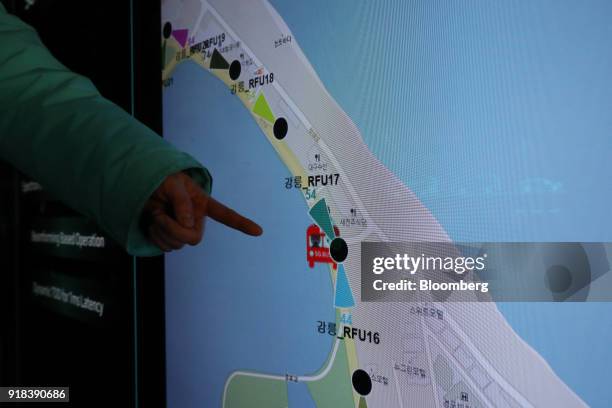 An employee points to a map displayed on a screen onboard an autonomous 5G connected bus, operated by KT Corp., during a media event in Gangneung,...