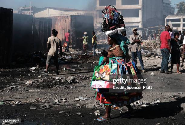 Haitians gather outside of Port-au-Prince's destroyed historic Iron Market after a fire yesterday on February 14, 2018 in Port-au-Prince, Haiti....
