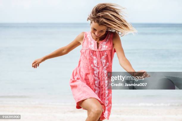 vrolijk lachende vrouw op het strand - roze jurk stockfoto's en -beelden