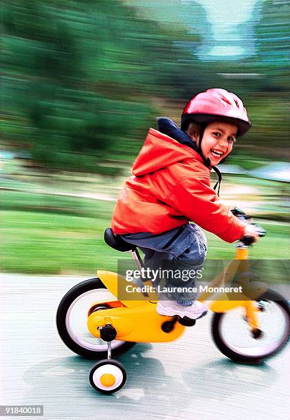 boy riding a bike with training wheels - training wheels stock pictures, royalty-free photos & images