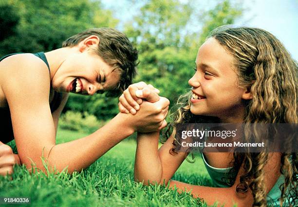 children arm wrestling - girl wrestling fotografías e imágenes de stock