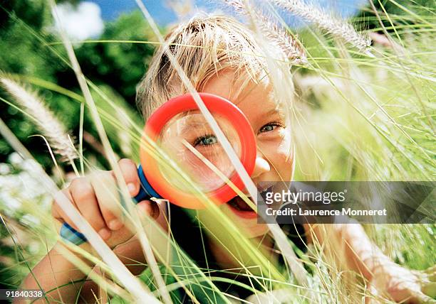 boy exploring with magnifying glass - explorer stock-fotos und bilder