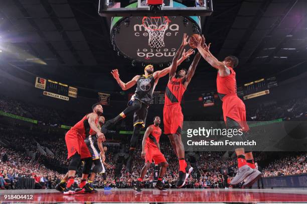 JaVale McGee of the Golden State Warriors Ed Davis and Damian Lillard of the Portland Trail Blazers reach for the rebound during the game between the...