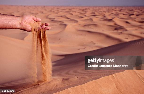 person sifting sand through hand - sifting stock pictures, royalty-free photos & images