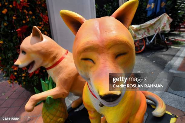 Dog figurines are diplayed in an alleyway on the eve of the Lunar New Year in the Chinatown district in Singapore on February 15, 2018. The Lunar New...