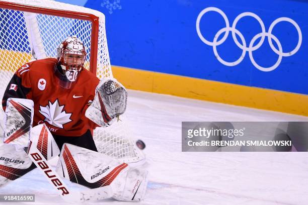 Canada's Genevieve Lacasse attempts to make a save in the women's preliminary round ice hockey match between the US and Canada during the Pyeongchang...