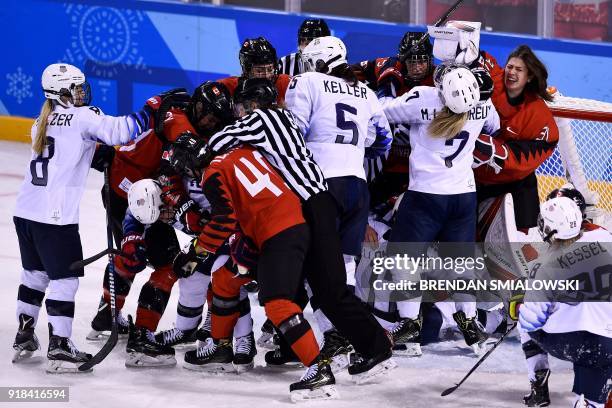 Players pile up on the Canadian goal in the women's preliminary round ice hockey match between the US and Canada during the Pyeongchang 2018 Winter...