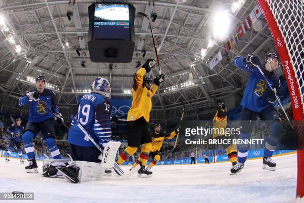 Germany's players react as teammate Frank Hordler scored in the men's preliminary round ice hockey match between Finland and Germany during the...