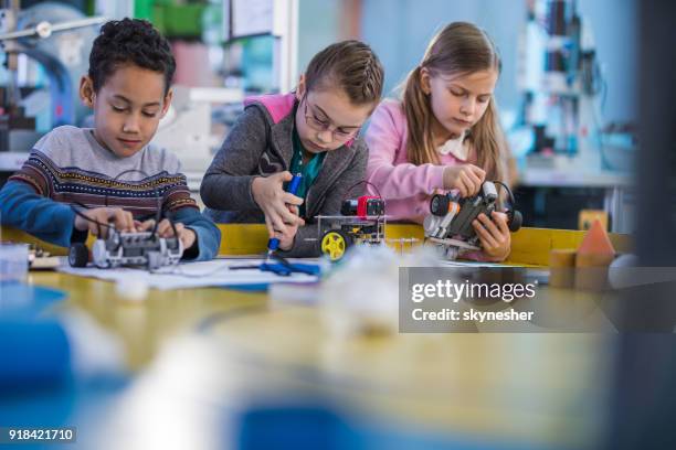group of small engineers working on innovative robots in school laboratory. - school science project stock pictures, royalty-free photos & images