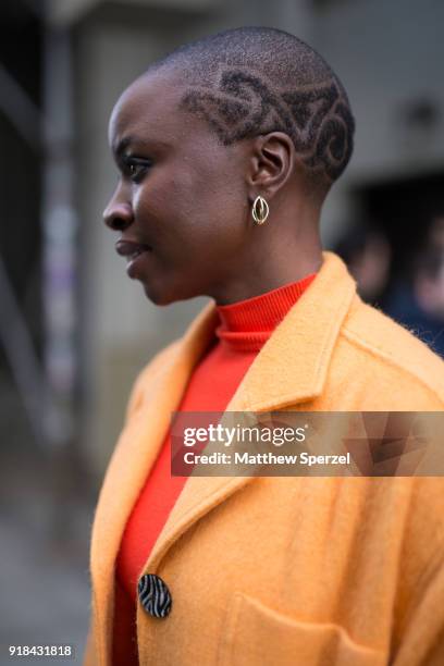 Danai Gurira is seen on the street attending EDUN during New York Fashion Week wearing a yellow coat with orange sweater and white pants on February...