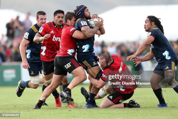 Jackson Hemopo of the Highlanders tries to break the tackle of Ben Funnell and Oli Jager of the Crusaders during the Super Rugby trial match between...