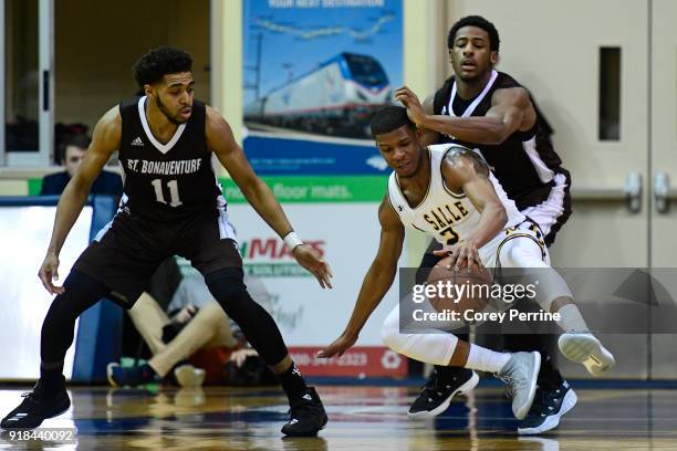 Amar Stukes of the La Salle Explorers loses his footing against Izaiah Brockington as Courtney Stockard of the St. Bonaventure Bonnies looks on...