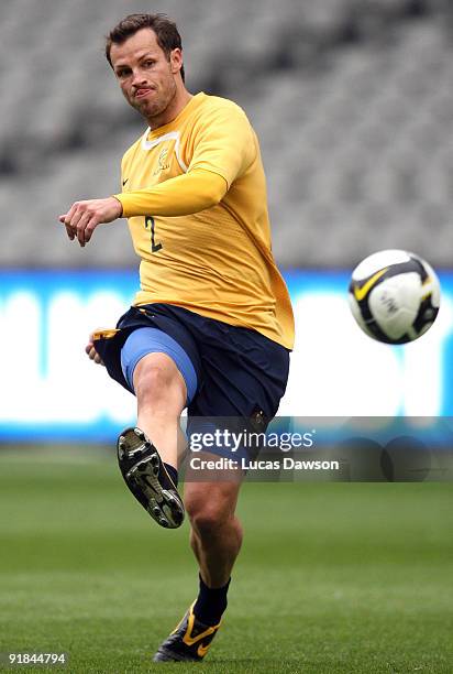 Lucas Neill of the Socceroos kicks the ball at an Australian Socceroos training session at at Etihad Stadium on October 13, 2009 in Melbourne,...