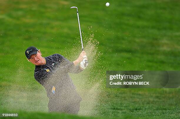 International team member Ernie Els of South Africa hits out of a bunker on the first hole during the final round singles matches of the Presidents...