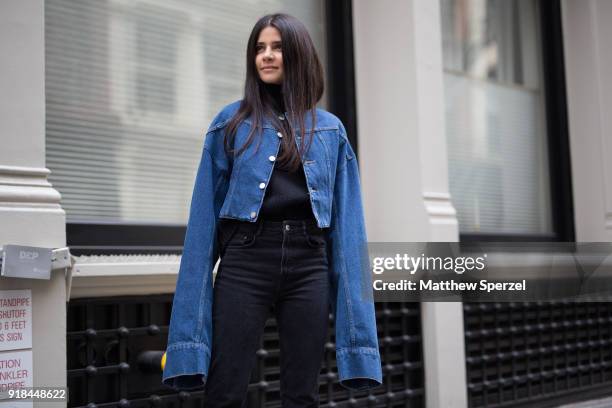 Guest is seen on the street attending EDUN during New York Fashion Week wearing a long sleeved denim jacket with black outfit on February 14, 2018 in...