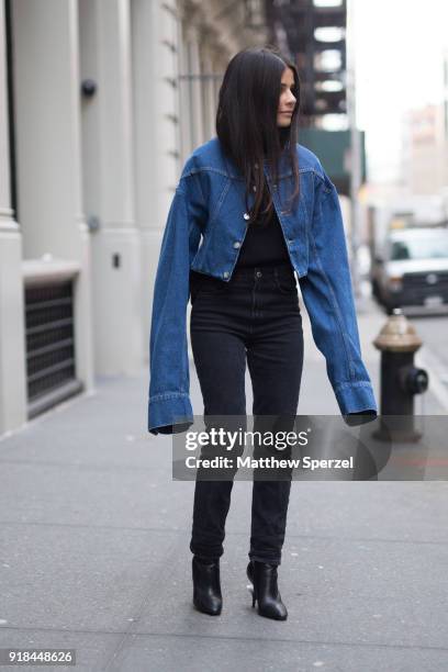 Guest is seen on the street attending EDUN during New York Fashion Week wearing a long sleeved denim jacket with black outfit on February 14, 2018 in...