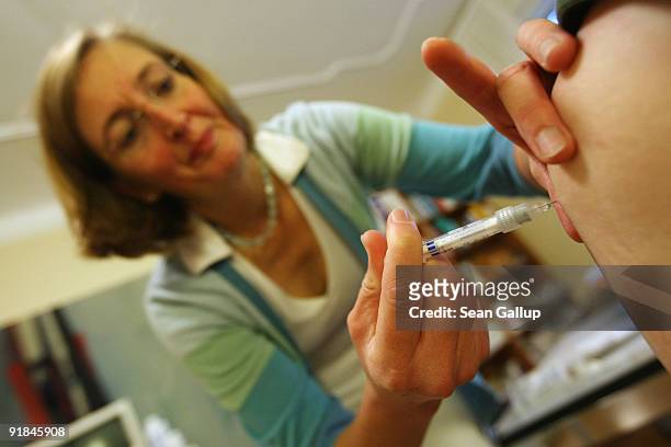 Family doctor gives an elderly patient a flu vaccine at her office on October 13, 2009 in Berlin, Germany. German political parties currently...