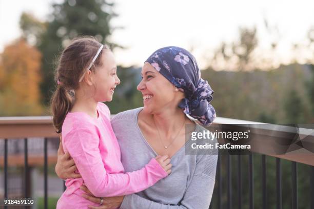 madre con cáncer abrazando a hija - cancer survivor fotografías e imágenes de stock