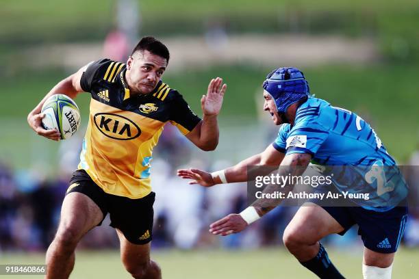 Chase Tiatia of the Hurricanes beats the tackle from Daniel Kirkpatrick of the Blues during the Super Rugby trial match between the Blues and the...