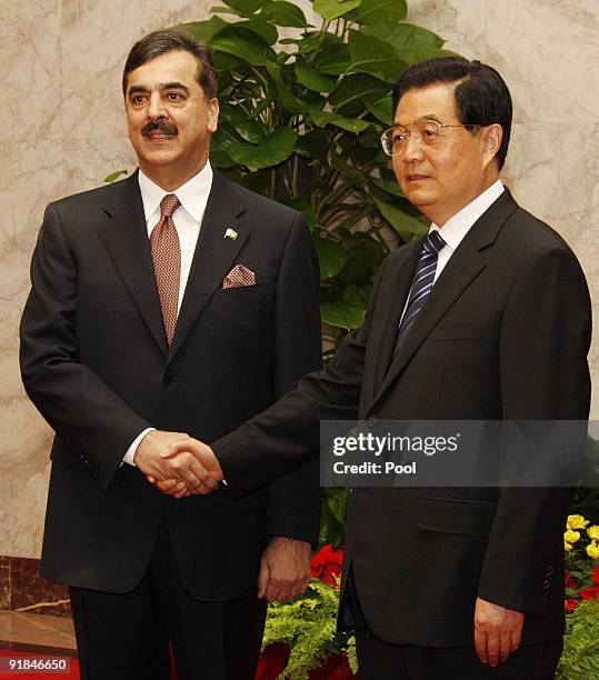 China's President Hu Jintao greets Pakistani Prime Minister Yousuf Raza Gilani prior to their talks at the Great Hall of the People on October 13 in...