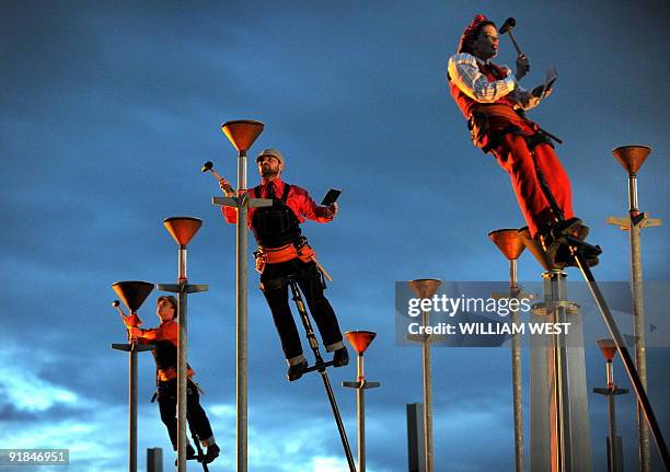 Members of the Melbourne outdoor theatre group Strange Fruit perform 'Ringing the Changes' which sees the performers perched atop five-metre poles...