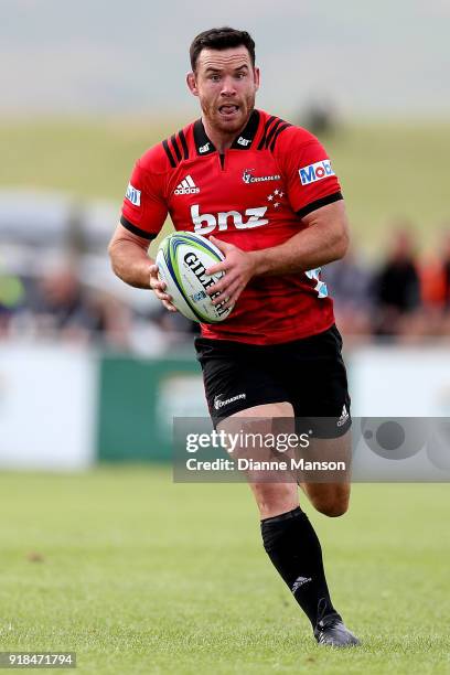 Ryan Crotty of the Crusaders runs the ball during the Super Rugby trial match between the Highlanders and the Crusaders at Fred Booth Park on...