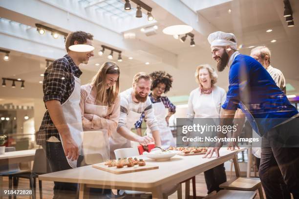 koken klasse deelnemers genieten van kookles - cooking class stockfoto's en -beelden