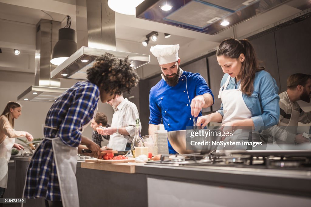 Young chef assisting a cooking class and explaining some tips and tricks