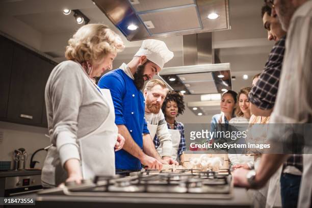 chef assisting a cooking class - cooking show stock pictures, royalty-free photos & images