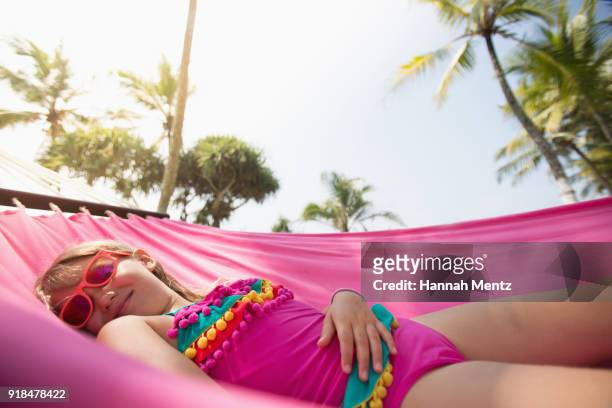 Little girl swinging in a pink hammock